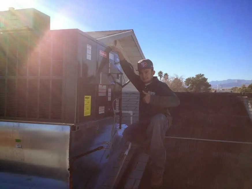 HVAC technician performing AC Tune-Up on a rooftop unit in Kearny